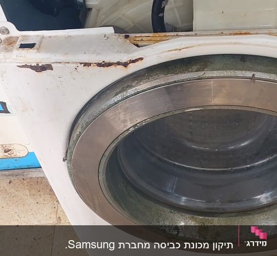מכונת כביסה ישנה עם חלודה וחלקים חשופים